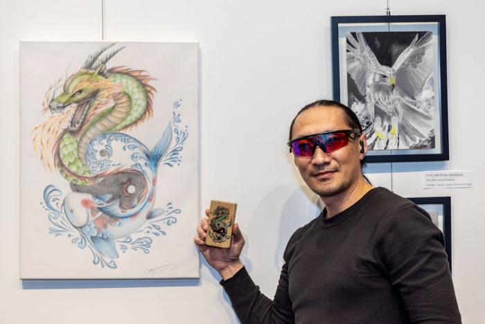 man standing next to dragon drawing